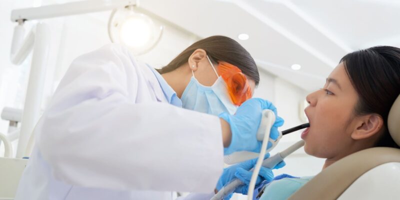 a dentist checking her patient's teeth