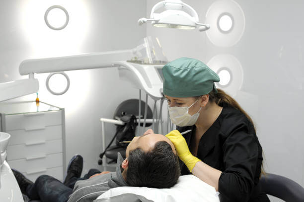 close-up of a dentist administering sedation to a calm patient