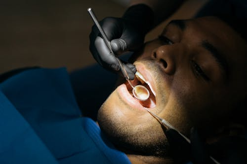 photo showing a man during a dental procedure, under a bright light