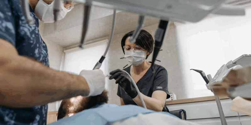 dental professionals performing dental cleaning on a patient