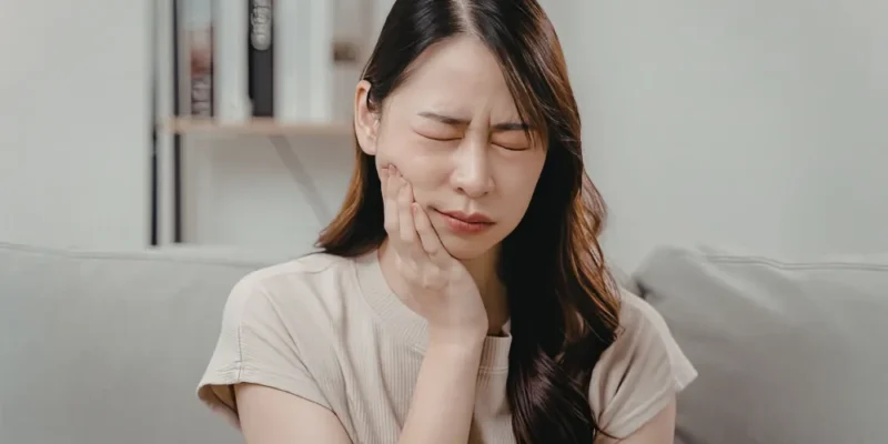 Woman with toothache pain holding cheek in Fort Walton Beach FL
