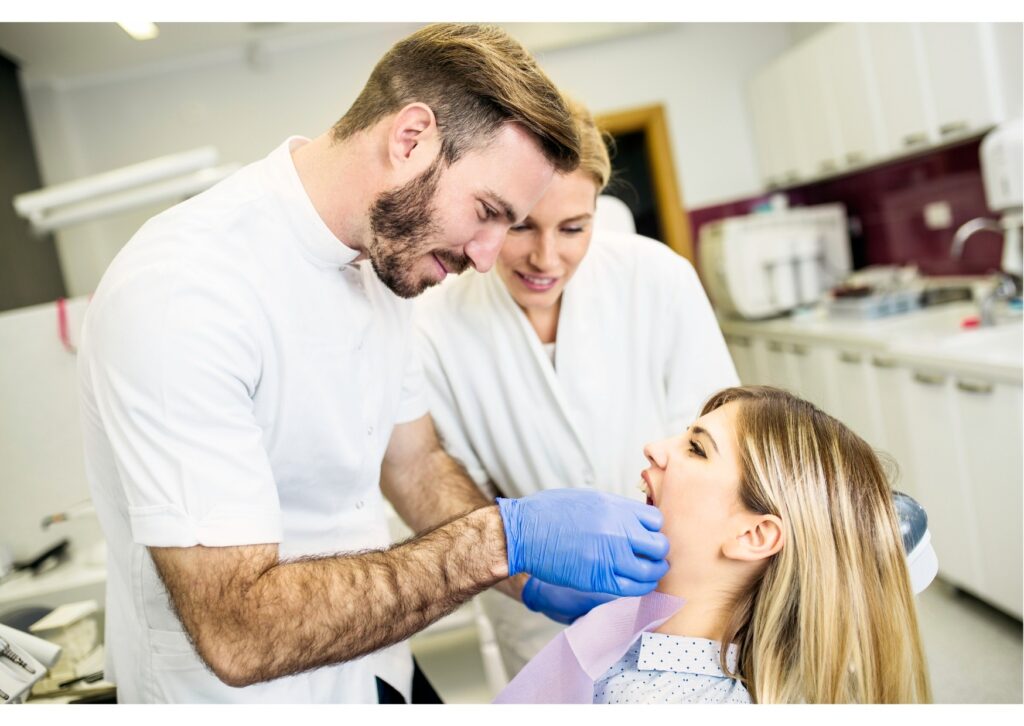 Dentist examining a patient while discussing dental implant treatment options and costs